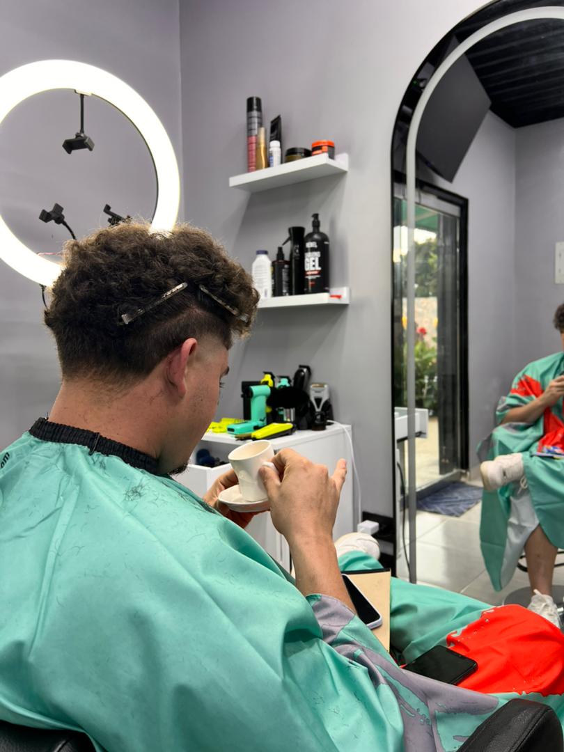 Cliente en la silla de Zane Barber Studio disfrutando de café de cortesía